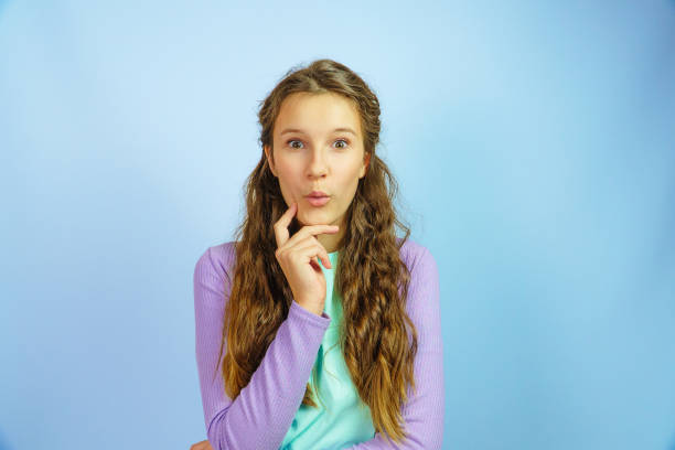 istock Surprised young girl on yellow background 2194897532