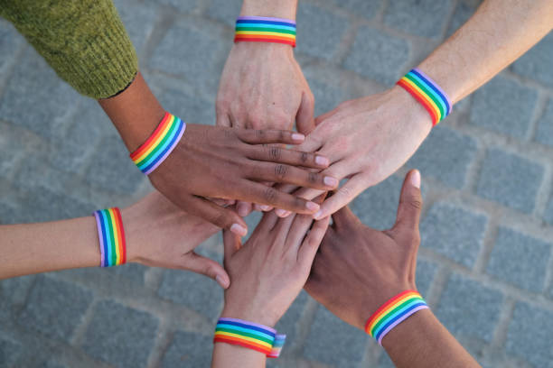 istock Activists joining hands wearing rainbow wristbands symbolizing lgbtq+ community 2194902280