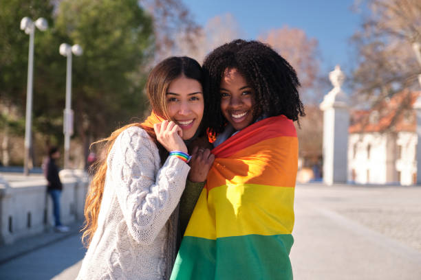 istock Two women holding rainbow flag smiling at camera 2194902756