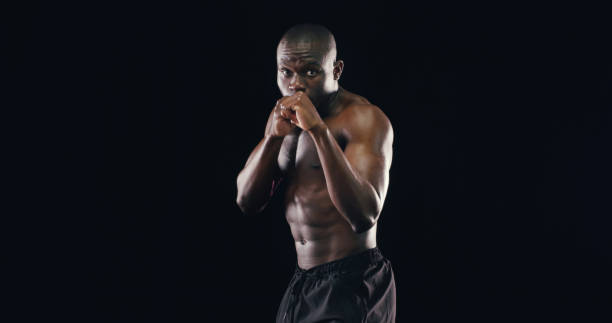Black man, boxer fighter and studio for exercise, challenge and battle courage on background. Male person, performance training and strong power with martial arts, portrait and athlete for sports