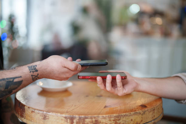 istock Close up to two mobile phones hand, wireless data transferring. 2194910113