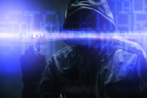 istock Stalkware concept with faceless hooded male person, low key image with digital glitch effect 2194911126