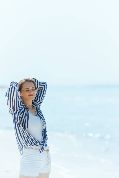 istock relaxed stylish woman on ocean shore enjoying tranquility 2194914027