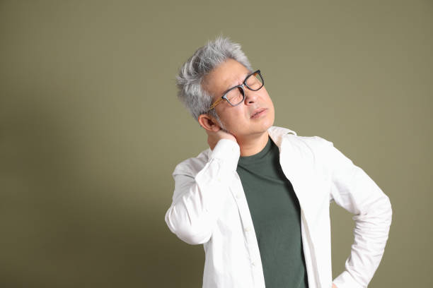 A half-body portrait of an East Asian businessman, isolated against a deep green background, taken in a studio.