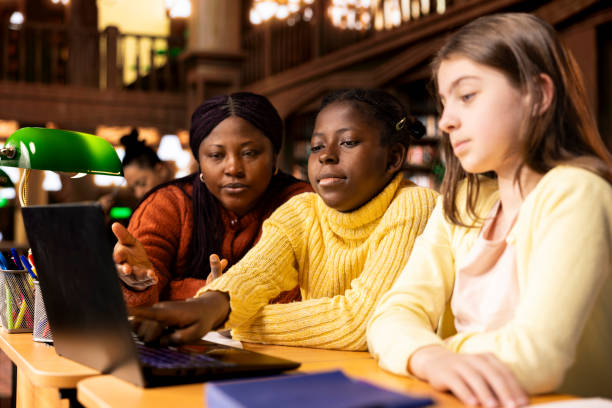 istock African american professor helps elementary students to practice writing essays 2194915676