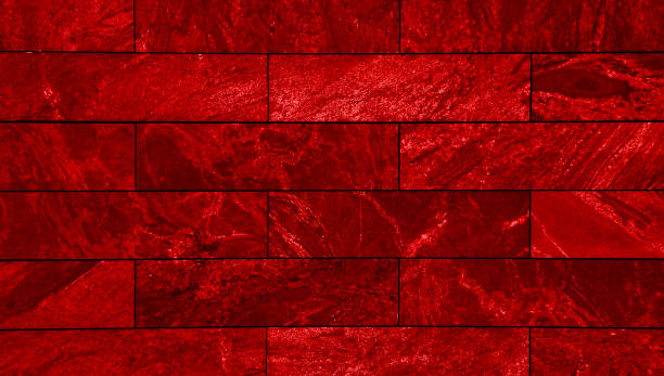 close-up view of a wall clad in rectangular red slate tiles, a smooth, uniform of marble stone surface with subtle variations in shade and texture, creating a visually appealing modern aesthetic.