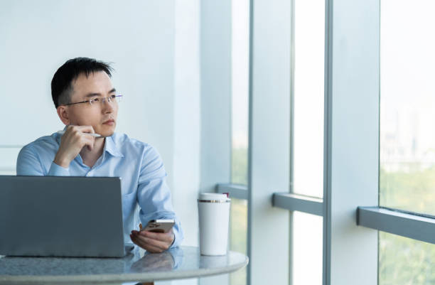 istock Businessman using laptop and mobile phone 2194919008
