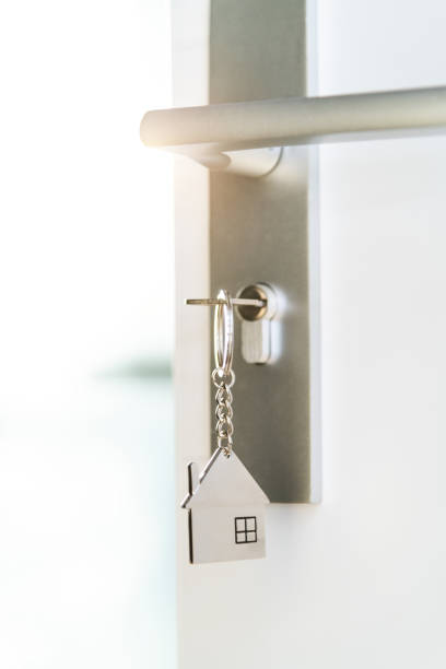 istock Open the door and door handle with a key and a house shaped silver keyring 2194919134