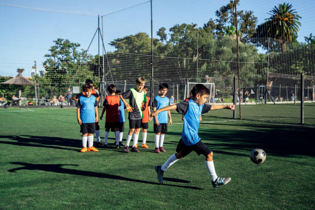 istock Children Practicing Soccer Skills on a Green Field in Team Uniforms 2194919215