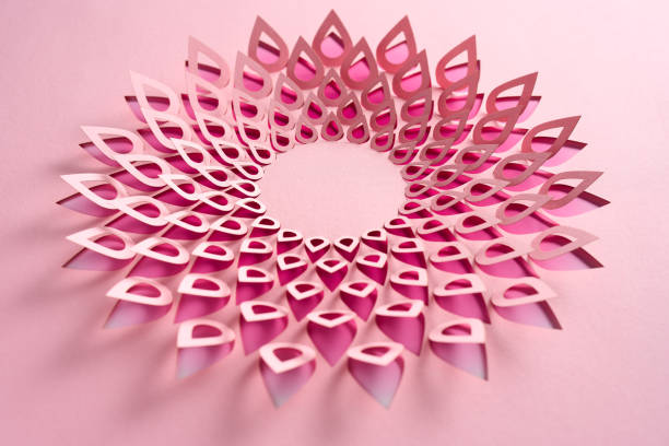 Delicate teardrop-shaped mandala crafted from layered cut paper, featuring pink tones arranged in a circular design. This intricate artwork highlights symmetry, depth, and softness, ideal for themes of creativity, femininity, and modern art.\nNative image size: 7952 x 5304.
