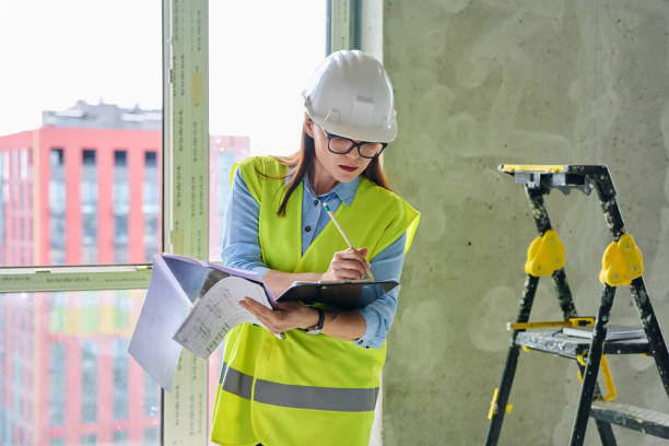 istock Technical profession woman in protective vest helmet working on construction 2194921393