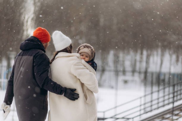 istock Young parents holding a child during a heavy snowfall 2194922434