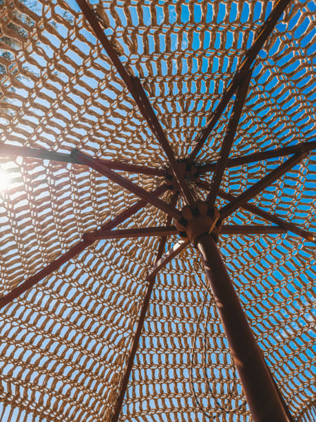 Looking up through a woven beach umbrella on a Greek island in summer