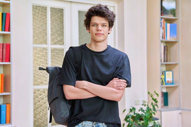 istock Portrait of college student guy with crossed arms inside educational building 2194932007