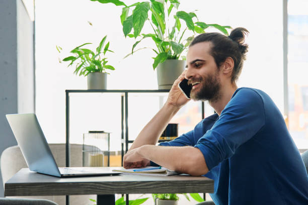 istock Smiling young handsome man talking on mobile phone 2194932575