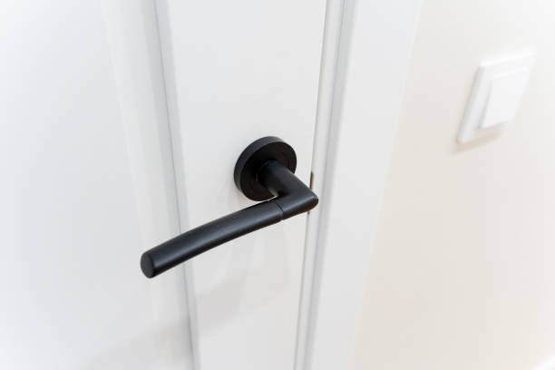 istock This is a detailed closeup image of a sleek black door handle that is elegantly placed on a pristine white door, showcasing the contrast between the two surfaces beautifully 2194932847