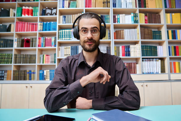 istock Webcam view young talking man making video call chat conference, in library 2194932851