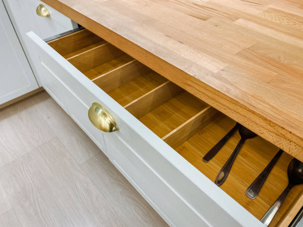 istock In the kitchen, there is a drawer loaded with various utensils, resting on a beautiful wooden counter top that enhances the overall aesthetic and functionality of the space 2194932953