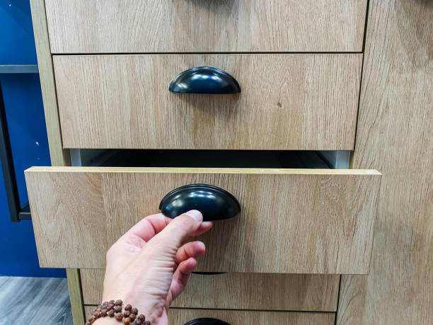 istock A person is opening a wooden drawer that features a sleek black handle, showcasing its craftsmanship and design, creating a sense of functionality and elegance in a home environment 2194932965