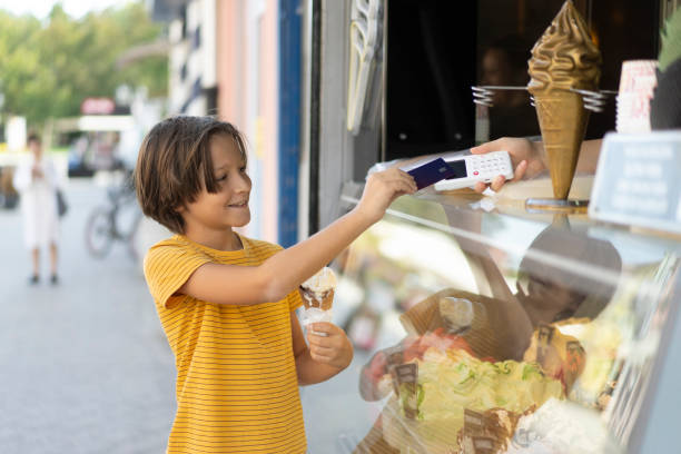 istock Child Enjoying Ice Cream and Making a Contactless Payment 2194933184