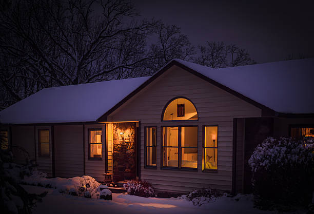 istock Suburban Midwestern house at night after snowfall with lit windows 2194935844