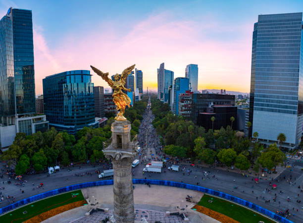 aerial view with drone of the statue of the angel of independence on Reforma Avenue with Chapultepec forest in the background