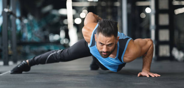 istock Muscular man doing push ups on on hands in gym 2194936935