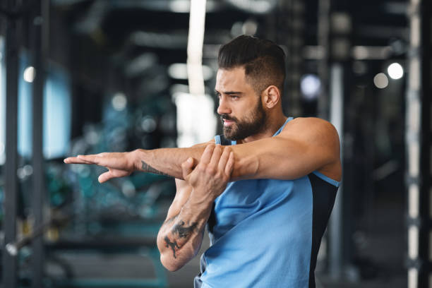 istock Sporty man at gym doing stretching exercises for hands 2194936942