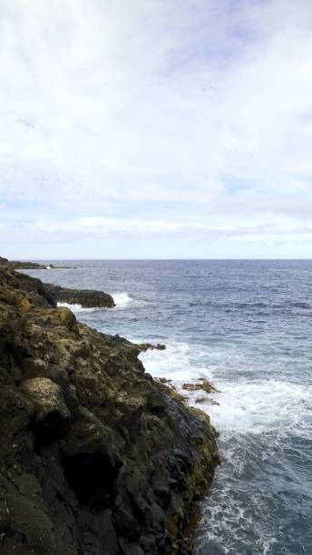 istock Ocean waves crashing against volcanic rocks 2194937839