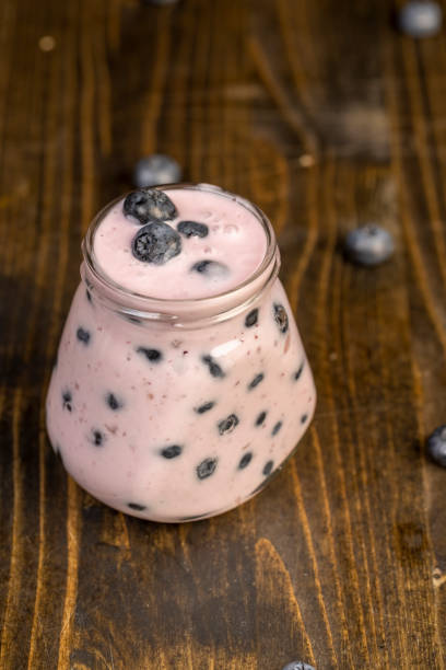 blueberries and yogurt with blueberries, closeup of a glass jar with blueberries and yogurt