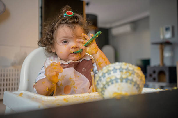 istock Playful Baby Making a Mess at Mealtime with a Spoon 2194940449