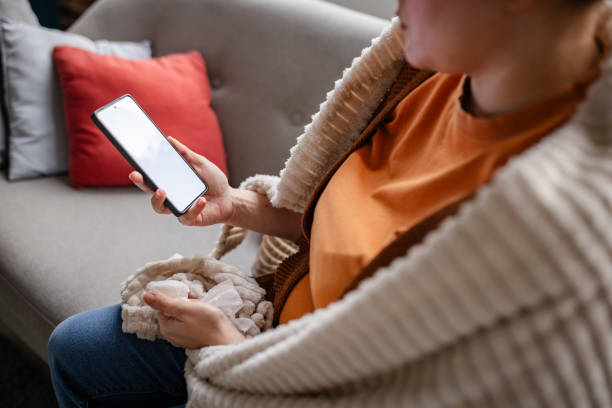 istock Modern comfort: Woman browsing phone, soft cushions. 2194941994