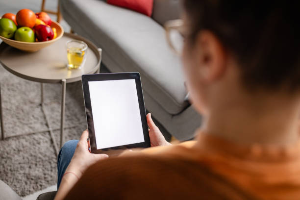istock View over woman’s shoulder, tablet and tea focus. 2194944079