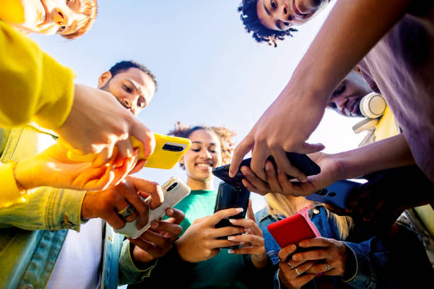 istock Young group of people using mobile phone outdoors. 2194947474