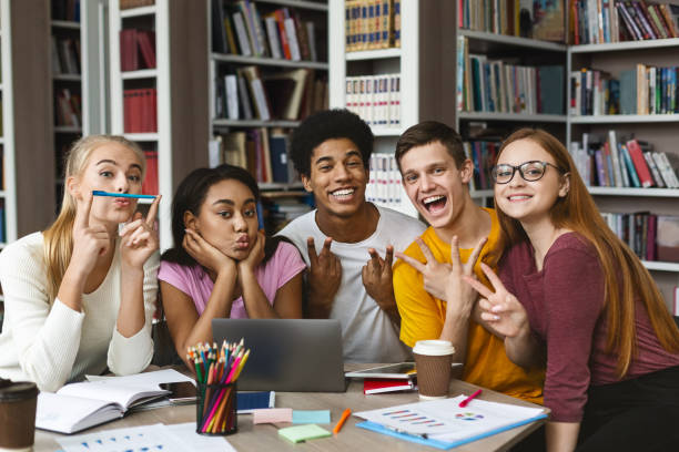 istock Group of Students Smiling and Making Peace Signs During Study Session at Library 2194952523