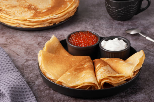 istock Delicious stack of golden pancakes served with cream and caviar on a rustic table 2194955133