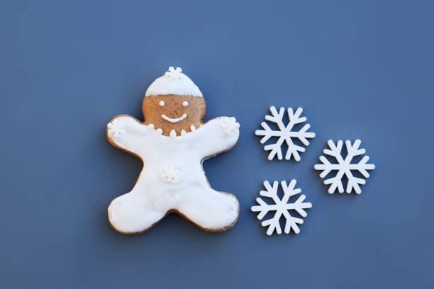 istock Smiling gingerbread man on a blue background with snowflakes 2194957975