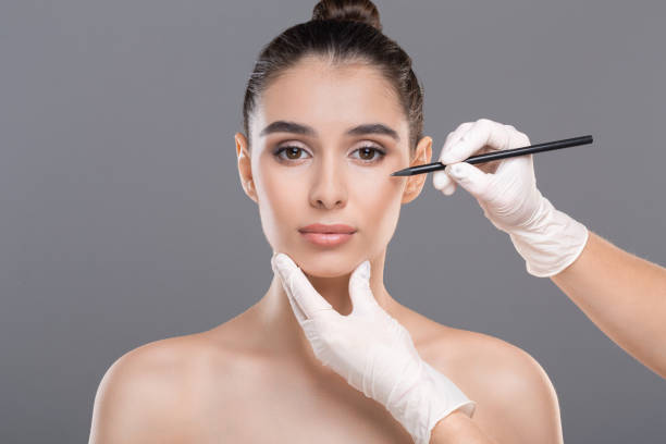 istock Female face with doctor's hands with pencil 2194957987
