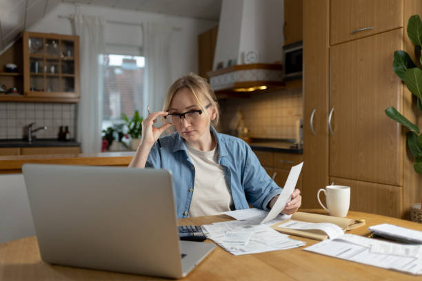 istock A calm environment and an organized workspace allow a woman to focus on remote work. Documents and a laptop are her main tools for doing quality work remotely 2194961029