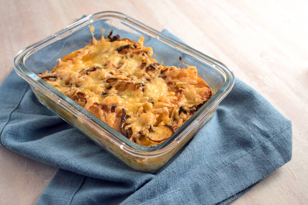istock Baked casserole with chicory, apple, onion and bacon gratinated with cheese in an ovenproof glass dish on a blue kitchen towel, copy space, selected focus 2194961662
