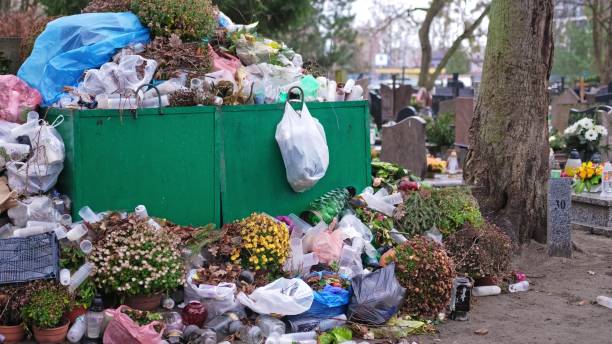 istock Overfilled Dumpster Container Full of Cemetery Graveyard Garve Decorations Garbage Flowers and Glass Death Candle Lanterns 2194964494