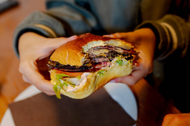 istock Customer holding a delicious burger in fast food restaurant 2194966358