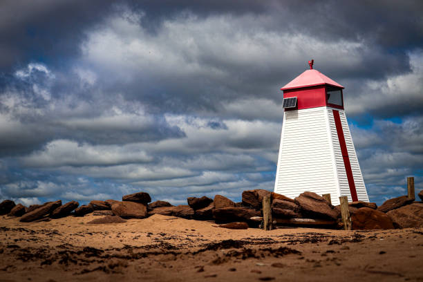 Lighthouse with red rocks around it. View from the shore of Murray Harbour Prince Edward Island, Canada