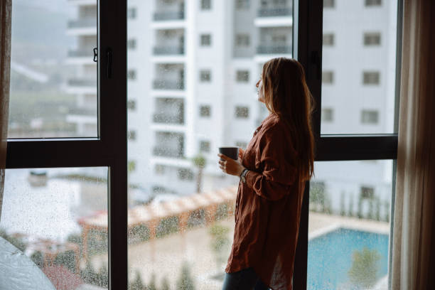 istock Women holding coffee cup while looking away at home 2194970032