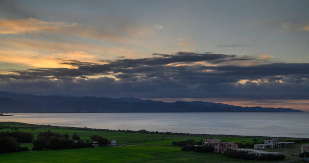 istock Scenic sunset over the tranquil seaside landscape with rolling hills and distant mountains in view 2194976722