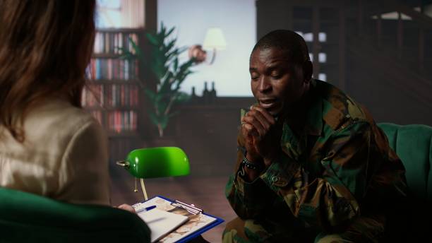 Black armed forces warrior faces trauma and anxiety at counseling session, addressing PTSD and talking about horror war scenes. Distraught trooper shares war flashbacks. Camera A.