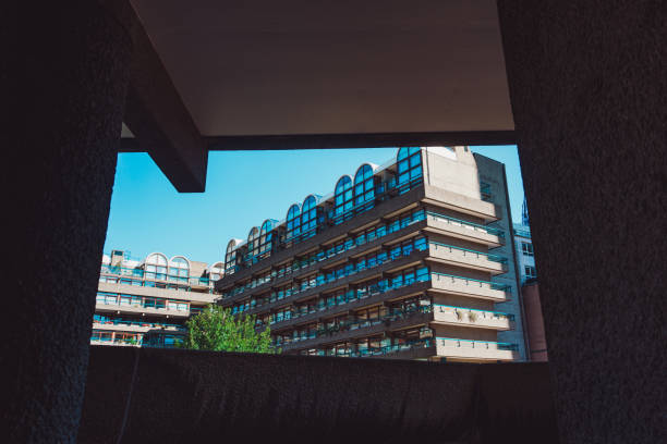 Modernist architecture of the barbican estate in london, seen from a concrete passageway on a sunny day