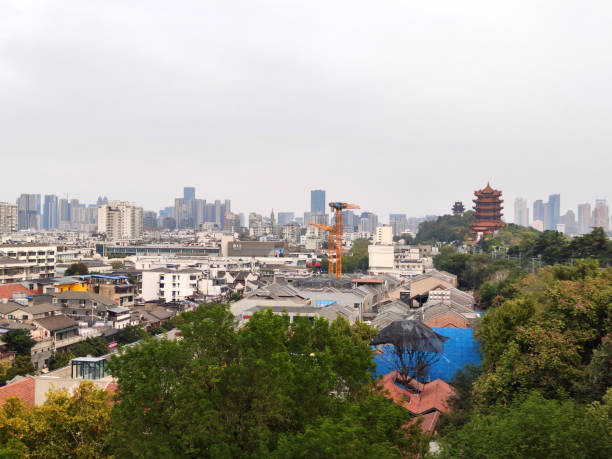 Wuhan skyline and the Yellow Crane Tower, a traditional Chinese tower. The current structure was built from 1981 to 1985, but the tower has existed in various forms from as early as AD 223. The current Yellow Crane Tower is 51.4 m and is situated on Snake Hill.