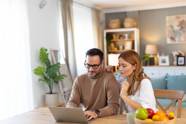istock Couple Collaborating in Bright Living Space with Laptop 2194981306