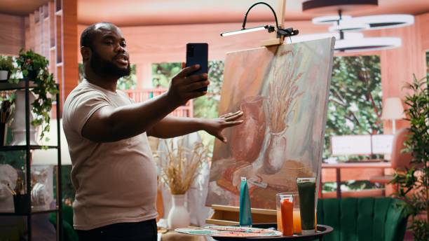 istock African american painter recording a video and self advertising his masterpiece 2194983343